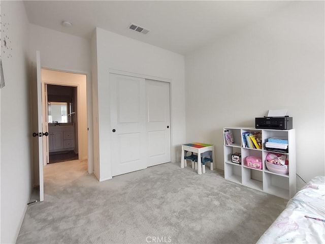 carpeted bedroom with visible vents and a closet