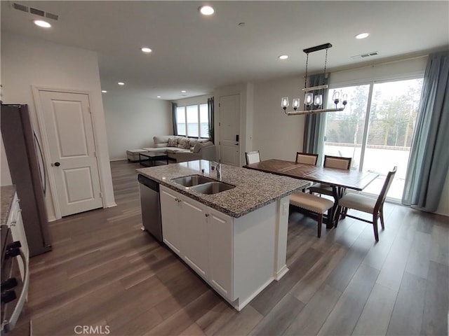 kitchen featuring dark wood-style floors, open floor plan, stainless steel appliances, and a sink