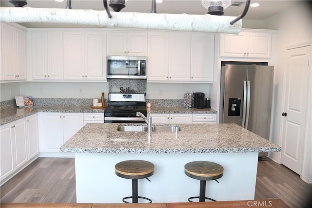 kitchen featuring a sink, white cabinets, light wood-style floors, and stainless steel appliances