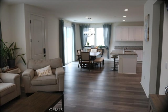 living room with a notable chandelier, recessed lighting, and dark wood-style floors