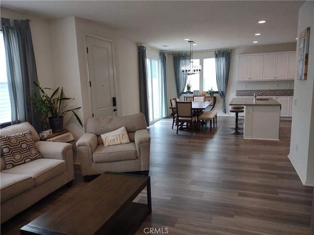 living area featuring dark wood-style floors, a notable chandelier, and recessed lighting