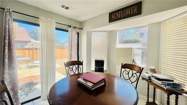 dining area featuring visible vents and a textured ceiling