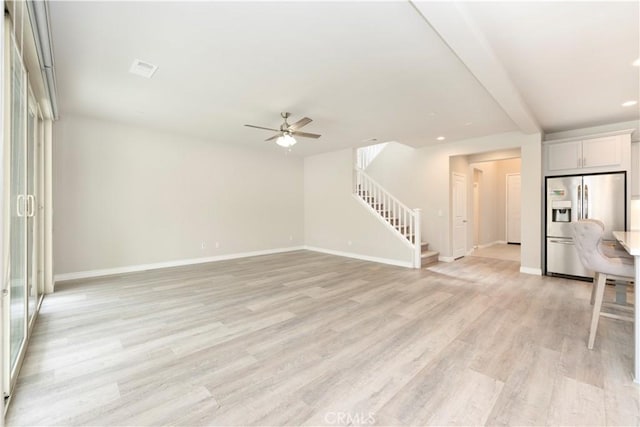 unfurnished living room with baseboards, light wood-style flooring, recessed lighting, ceiling fan, and stairs