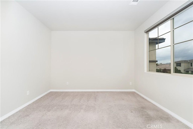 carpeted spare room with visible vents and baseboards