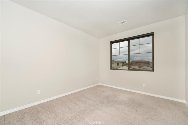 carpeted empty room featuring visible vents and baseboards