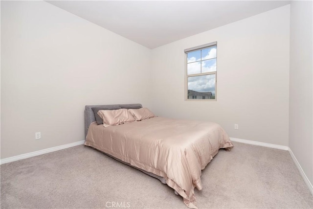 bedroom featuring light colored carpet and baseboards