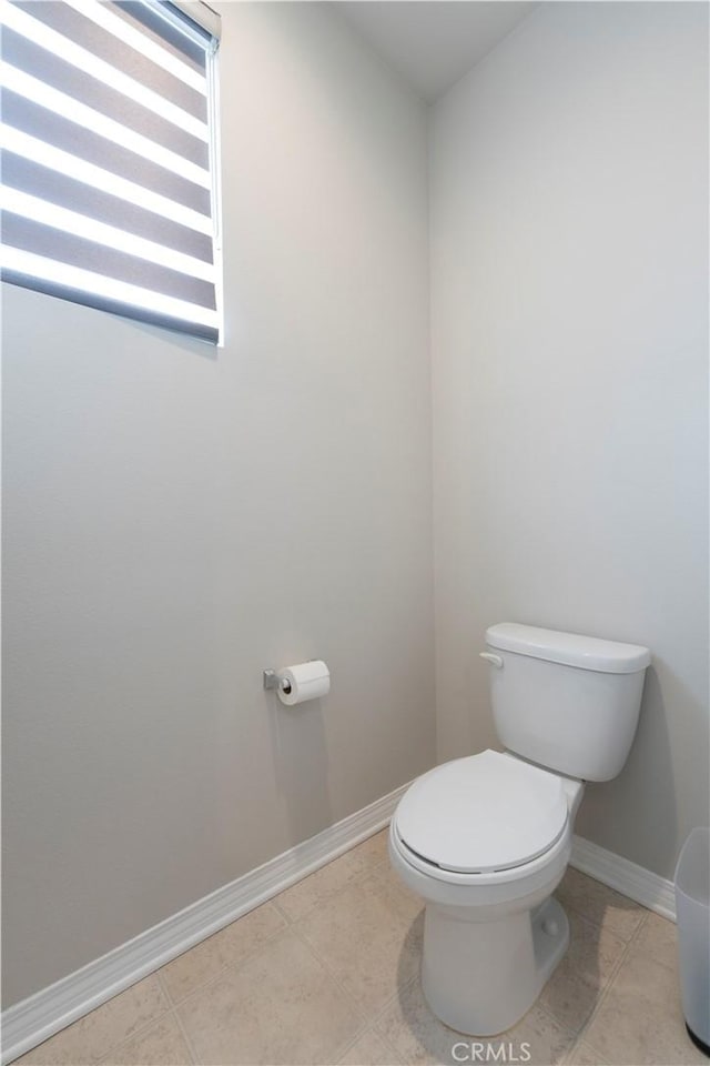 bathroom with toilet and baseboards