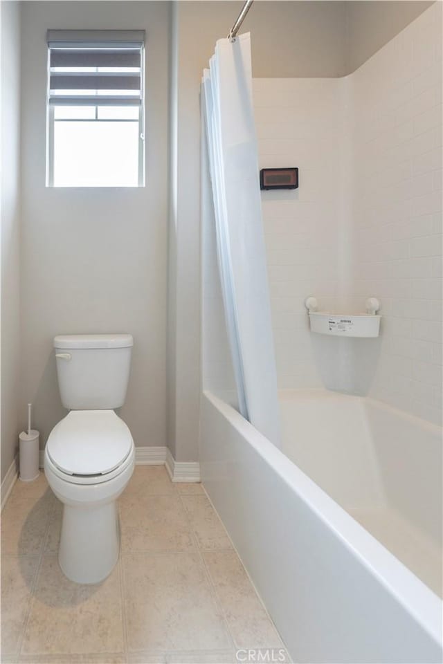 full bathroom featuring baseboards, toilet, shower / bath combo, and tile patterned flooring