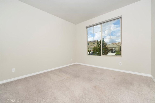 spare room featuring carpet and baseboards