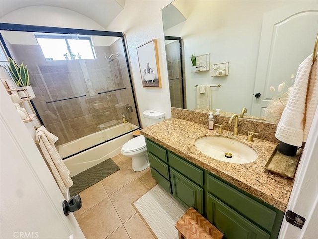 full bathroom with combined bath / shower with glass door, toilet, vanity, and tile patterned flooring