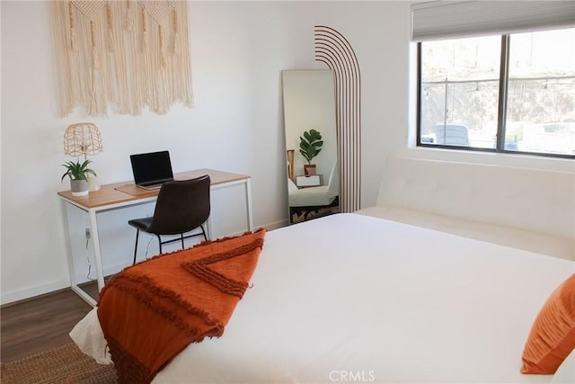 bedroom with wood finished floors and baseboards