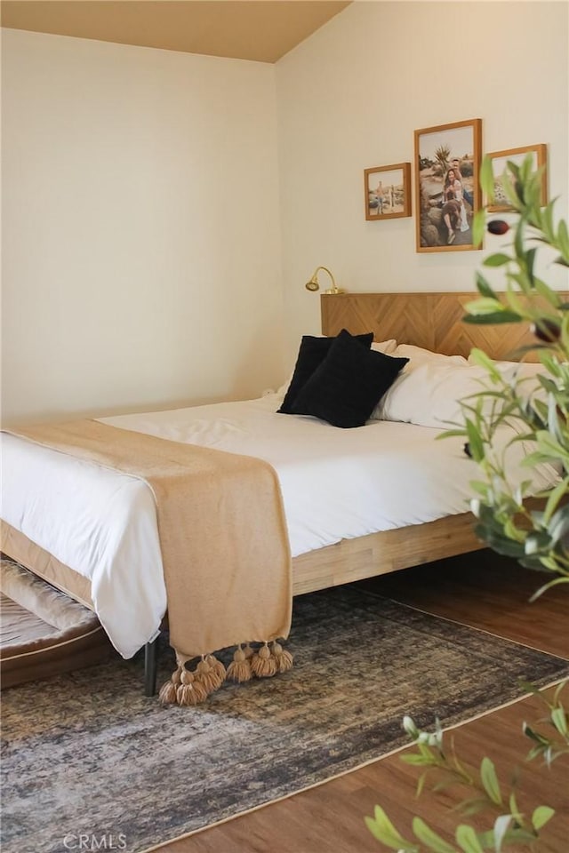 bedroom featuring lofted ceiling and wood finished floors