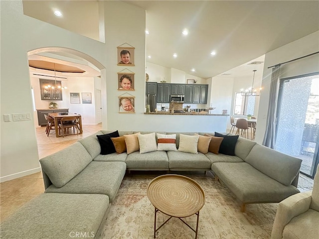 living room with an inviting chandelier, light tile patterned flooring, arched walkways, and high vaulted ceiling