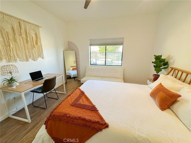 bedroom with a ceiling fan, wood finished floors, and baseboards