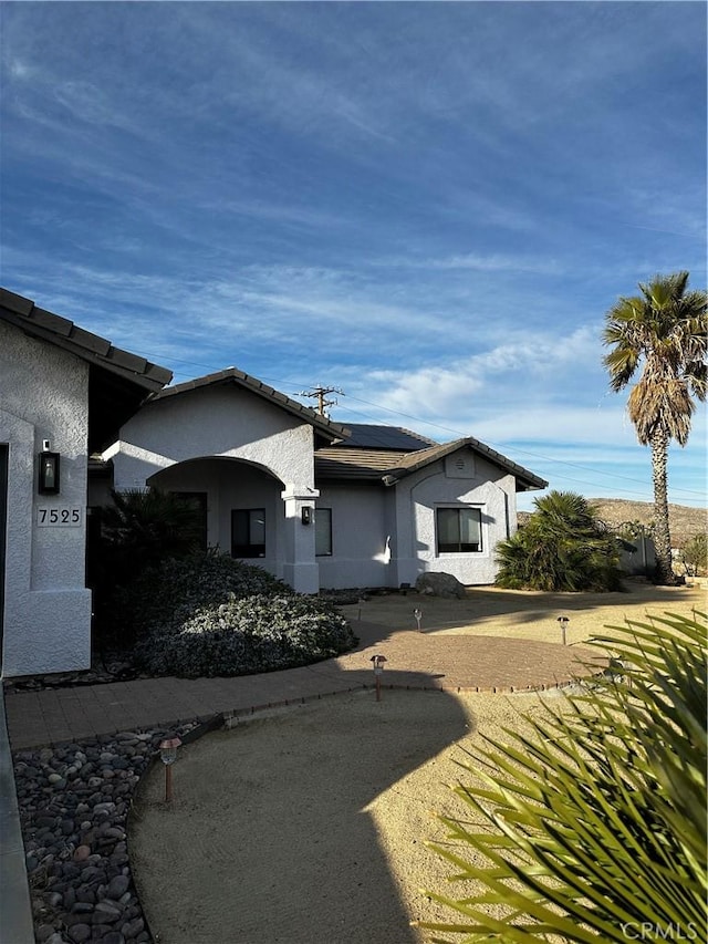 view of property exterior featuring stucco siding and solar panels