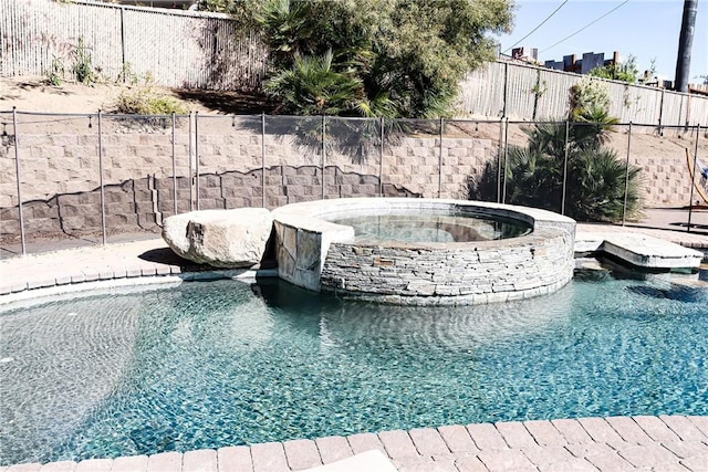 view of pool with a pool with connected hot tub and a fenced backyard