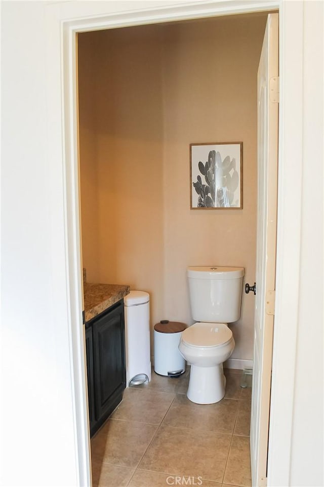 bathroom featuring vanity, tile patterned floors, and toilet