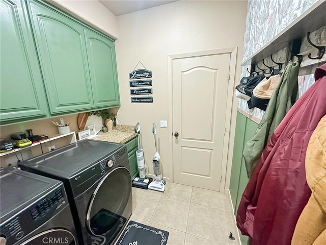 clothes washing area featuring tile patterned floors, cabinet space, and washing machine and dryer