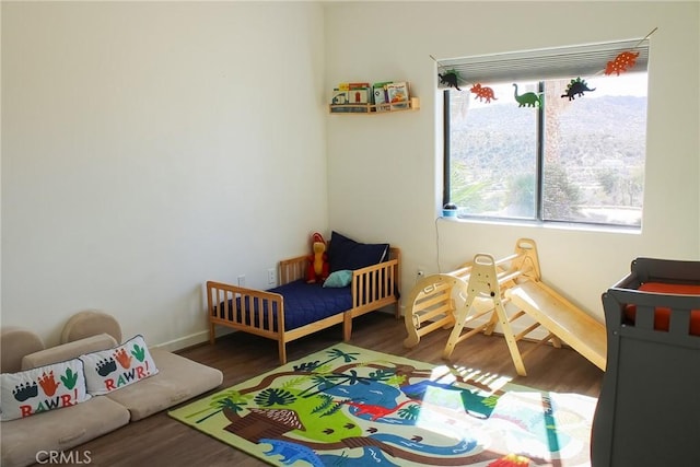 bedroom with baseboards and wood finished floors