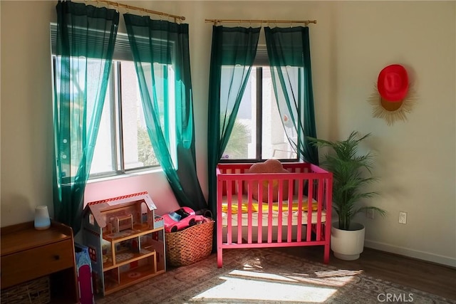 bedroom with baseboards and wood finished floors