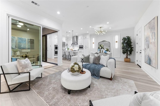 450 Chorus, Irvine, CA 92618 - living area with visible vents, ornamental molding, recessed lighting, ceiling fan with notable chandelier, and light wood-style floors