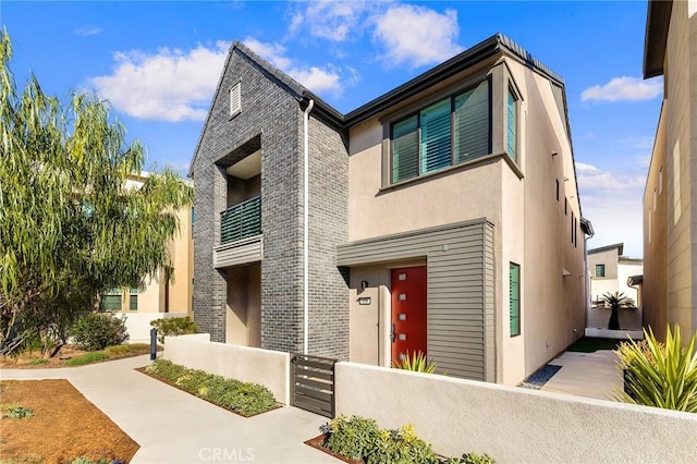 450 Chorus, Irvine, CA 92618 - view of front of property featuring a balcony, a fenced front yard, and stucco siding