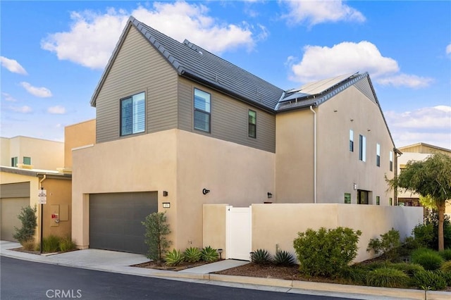 450 Chorus, Irvine, CA 92618 - view of front of house with fence, stucco siding, concrete driveway, a garage, and roof mounted solar panels
