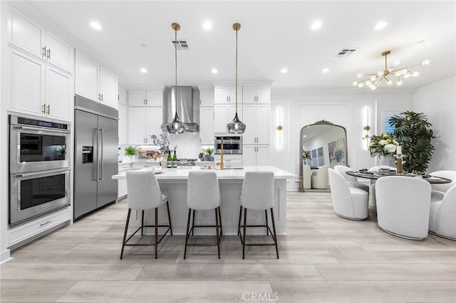 450 Chorus, Irvine, CA 92618 - kitchen featuring visible vents, a notable chandelier, appliances with stainless steel finishes, wall chimney exhaust hood, and light countertops