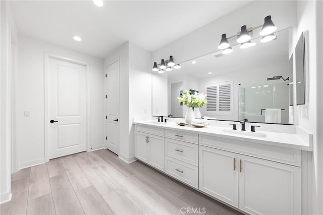 450 Chorus, Irvine, CA 92618 - bathroom featuring double vanity, wood finished floors, a stall shower, and a sink