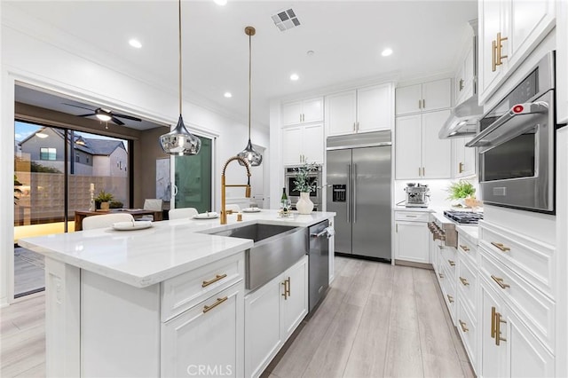 450 Chorus, Irvine, CA 92618 - kitchen featuring visible vents, a kitchen island with sink, a sink, stainless steel appliances, and white cabinets