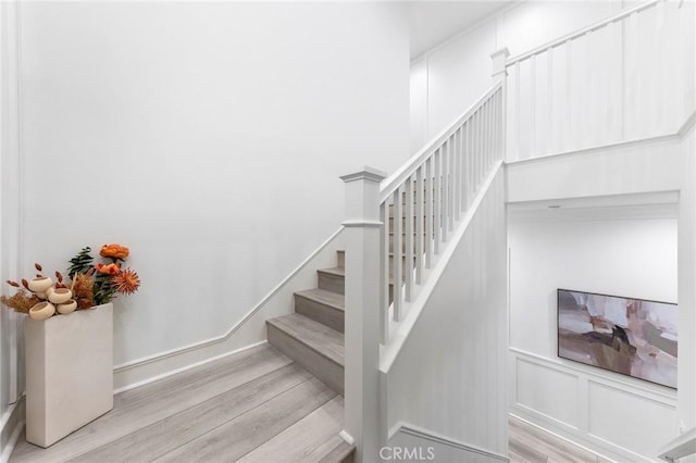 450 Chorus, Irvine, CA 92618 - stairs featuring baseboards, wood finished floors, and a decorative wall