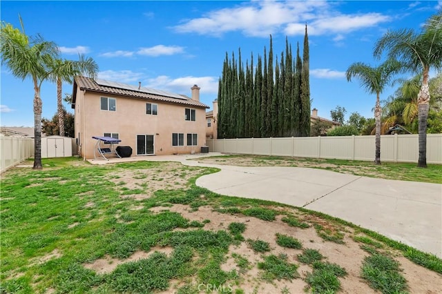 29193 Via Espada, Murrieta, CA 92563 - back of property with a patio, roof mounted solar panels, a fenced backyard, stucco siding, and a chimney