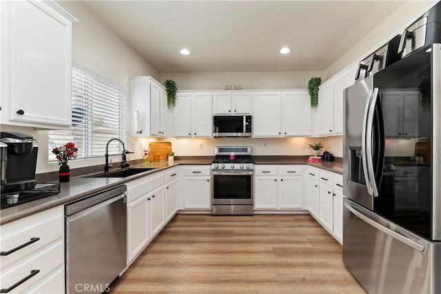 29193 Via Espada, Murrieta, CA 92563 - kitchen with stainless steel appliances, a sink, white cabinets, recessed lighting, and light wood finished floors