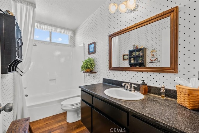 full bathroom featuring toilet, wood finished floors, vanity, and wallpapered walls