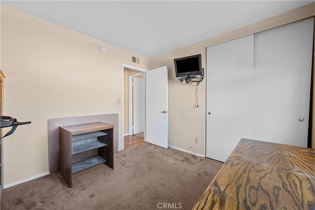 bedroom with carpet flooring, baseboards, visible vents, and a closet