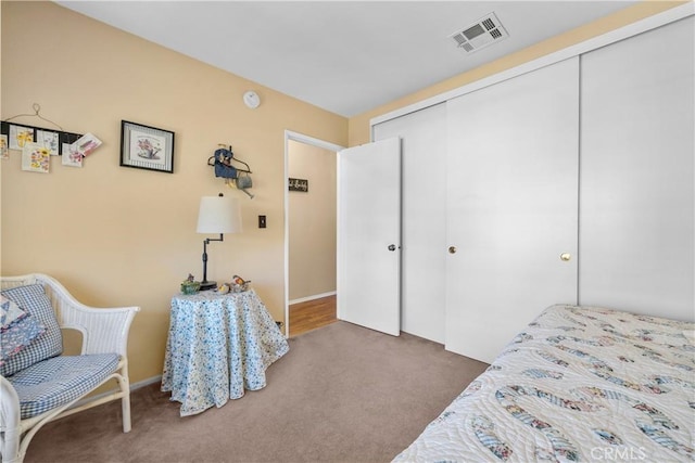 carpeted bedroom with visible vents and a closet