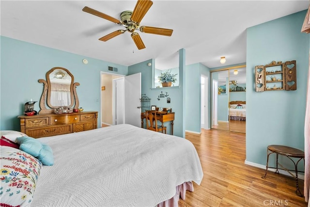 bedroom with light wood-type flooring, visible vents, baseboards, and ceiling fan