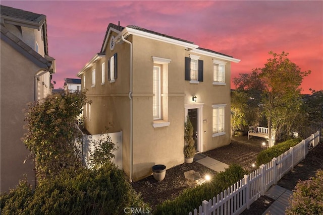 view of front of property featuring stucco siding and fence