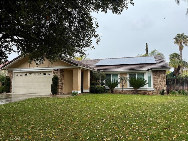 ranch-style home with a front lawn, concrete driveway, roof mounted solar panels, stucco siding, and stone siding