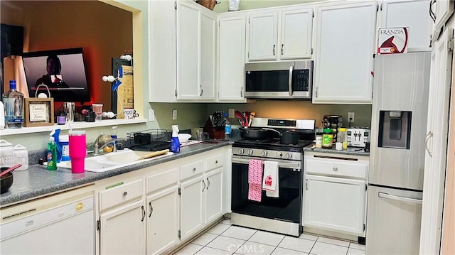 kitchen with white cabinets, light tile patterned floors, appliances with stainless steel finishes, and a sink