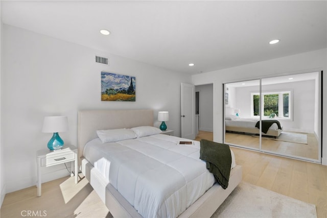 bedroom with recessed lighting, visible vents, a closet, and light wood finished floors