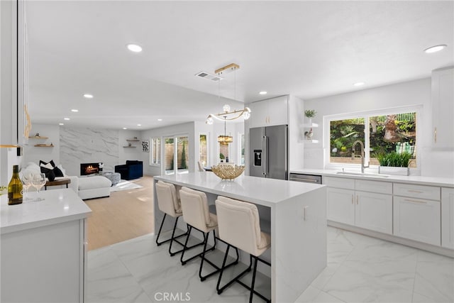 kitchen with visible vents, marble finish floor, a sink, recessed lighting, and appliances with stainless steel finishes