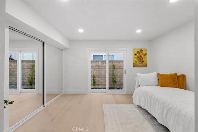 bedroom featuring recessed lighting, light wood-style flooring, baseboards, and access to outside