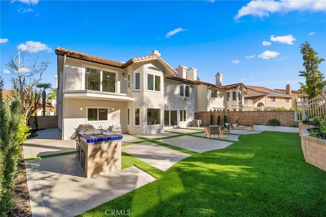 rear view of property with area for grilling, a yard, a fenced backyard, stucco siding, and a patio area