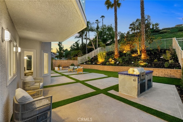 patio terrace at dusk with a fenced backyard