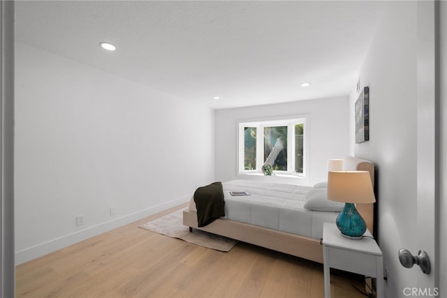 bedroom with recessed lighting, baseboards, and wood finished floors