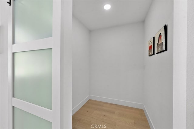 hallway featuring baseboards and wood finished floors