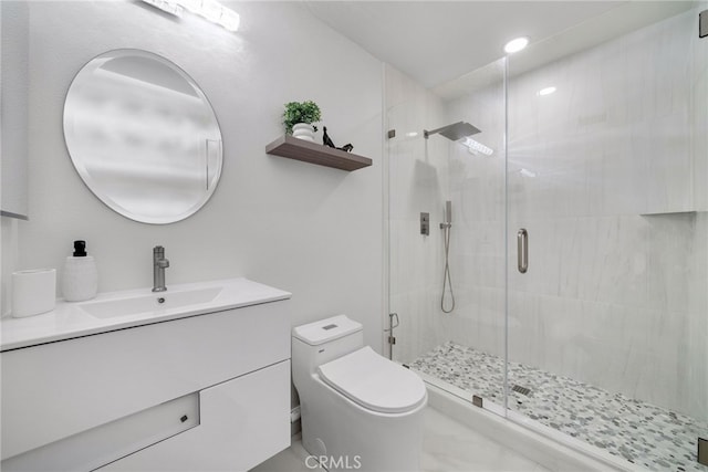 bathroom featuring toilet, a stall shower, and vanity