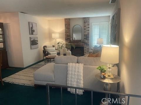 living area featuring visible vents and a brick fireplace