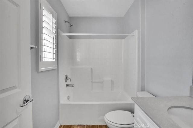 full bath with shower / tub combination, toilet, vanity, and wood finished floors